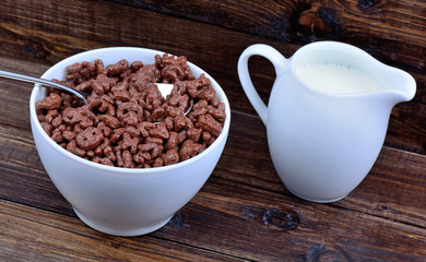 Cocoa cereals in a bowl with milk on table