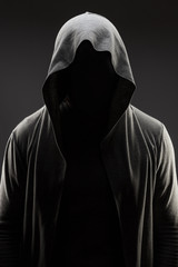 mysterious man in the hood with hidden face over dark grey background - obrazy, fototapety, plakaty
