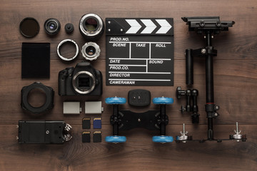 Fototapeta premium different video making equipment for indie production on brown wooden table view from above. short movie production essentials
