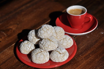 red cup of espresso with lemon crinkle cookies on wooden table