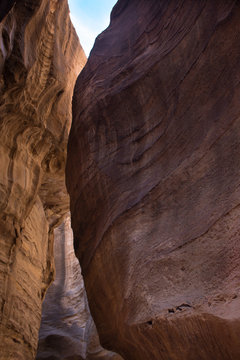 The orange walls of Al Siq, the caravan passageway in Petra, Jordan, leading to the Treasury. The narrow, high walled gorge is a natural fault in the mountain now eroded by water.