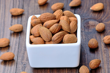 Group of almonds in a ceramic bowl on table