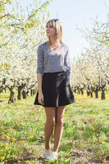 Portrait of beautiful young woman in apple trees blooming park on a sunny day. Smiling girl Happy girl. Happiness concept.