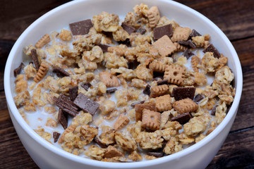 Muesli with milk in a ceramic bowl on table