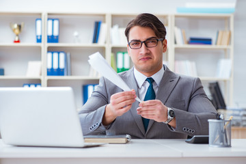 Businessman with paper airplane in office