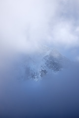 A mountain flashes through the clouds in Himalaya, Nepal