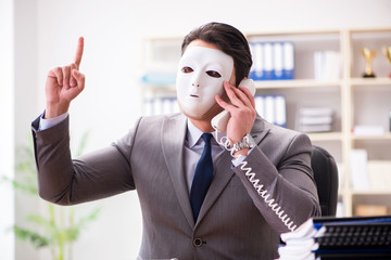 Businessman with mask in office hypocrisy concept