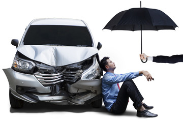 Businessperson with dented car and umbrella