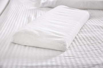 White orthopedic pillow on bed