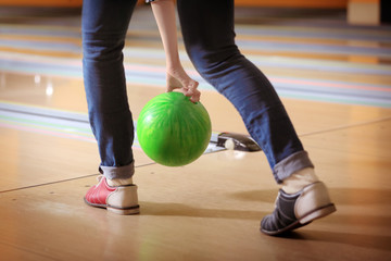 Fototapeta na wymiar Young woman throwing ball in bowling club
