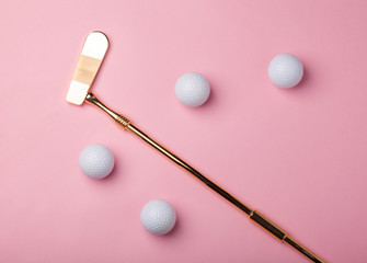 luxury golden golf club with golf balls isolated on pink background