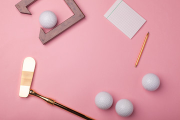 blank notepad, pencil, luxury golden golf club with golf balls isolated on pink background