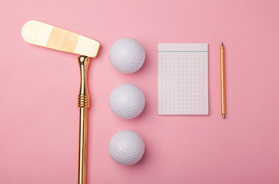 blank notepad, pencil, luxury golden golf club with golf balls isolated on pink background
