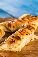 Slices of baked cheese pie served on the retro rustic round wooden board
