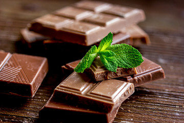 black and milk chocolate bars dark wooden table background