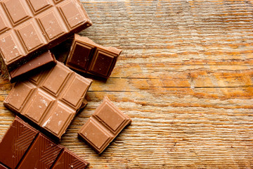 black chocolate pattern on wooden background top view space for text