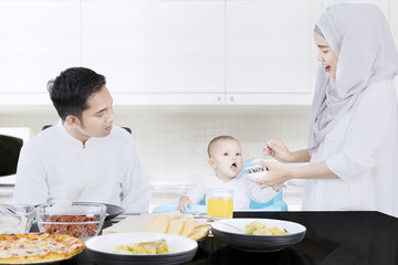 Muslim parents feeding their baby