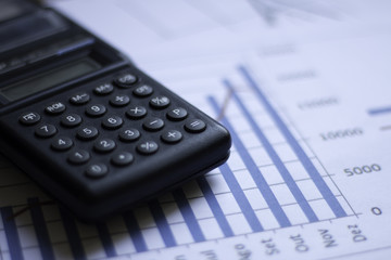 Calculator on papers with finance chart