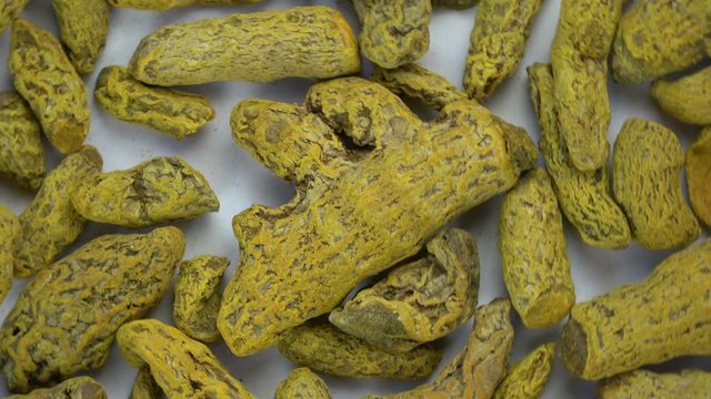 Rotation dry turmeric cucurma roots, spice background