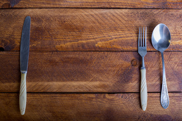 Fork, spoon, knife on the wooden table background with copy place. Concept kitchen and restaurant service. Top view