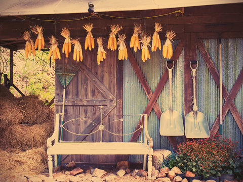 Old chair, gardening tools in front of barn, vintage filter effect