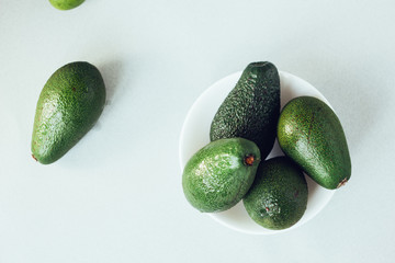 Fresh organic avocado in white ceramic bowl.