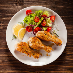 Grilled chicken drumstick on wooden table