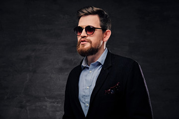 Fototapeta premium An elegant bearded male dressed in cotton velvet suit and sunglasses.