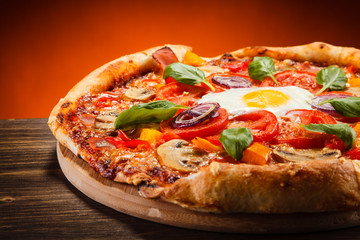 Pizza with egg and mushrooms on wooden table