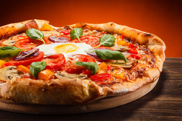 Pizza with egg and mushrooms on wooden table