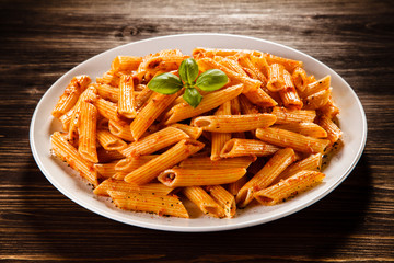 Pasta with tomato sauce on wooden table
