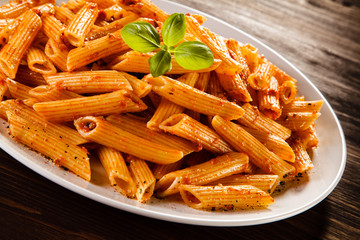 Pasta with tomato sauce on wooden table