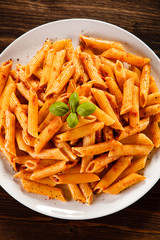 Pasta with tomato sauce on wooden table