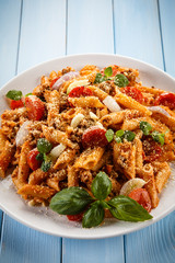 Pasta with tomato sauce and parmesan on blue planks