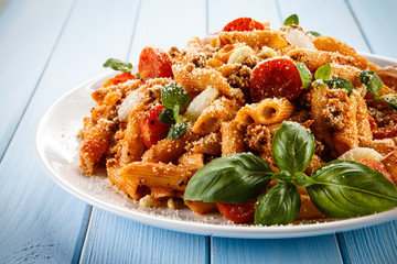 Pasta with tomato sauce and parmesan on blue planks
