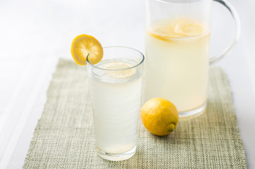 Lemonade glass and pitcher.  Lemonade is traditionally a homemade drink made with squeezed lemon, water and sugar, a simple recipe for a quick refreshing summer drink packed with vitamin c.