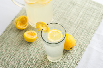 Lemonade juice with lemon slices.  Lemonade is traditionally a homemade drink made with squeezed lemon, water and sugar, a simple recipe for a quick refreshing summer drink packed with vitamin c.