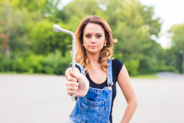 Young sexy woman with wrench in hands outdoor