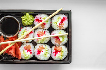The plate of sushi with soy sauce, wasabi and chopsticks
