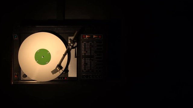 Vinyl record pleer. Plays song from an old turntable 4k top view. Black background. Music round plate rotate. Music disc turn. Tracking shot rotating disk with chroma-key green screen. Tracking point.