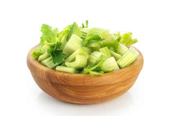 Fresh sliced celery in a wooden bowl isolated on white background.