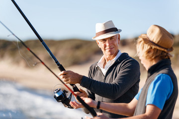 Senior man fishing with his grandson