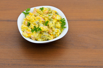 Russian traditional salad olivier on wooden table