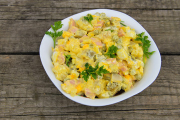 Russian traditional salad olivier on wooden table