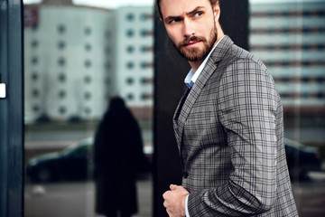 portrait of sexy handsome fashion male model man dressed in elegant checkered suit .posing near...