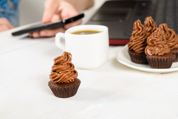 Working at home and eating unhealthy chocolate cupcake for breakfast