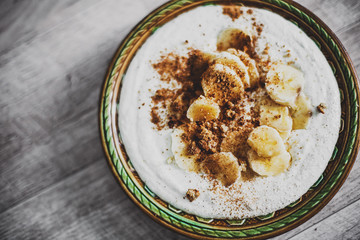 ice cream with bananas and nuts on aged background