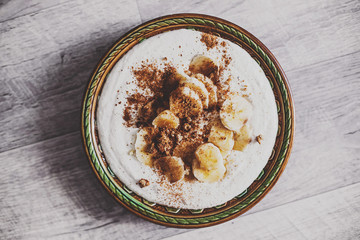 ice cream with bananas and nuts on aged background