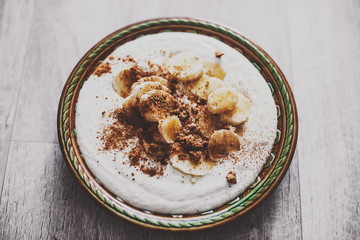 ice cream with bananas and nuts on aged background