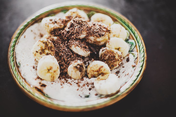 ice cream with bananas and nuts on aged background